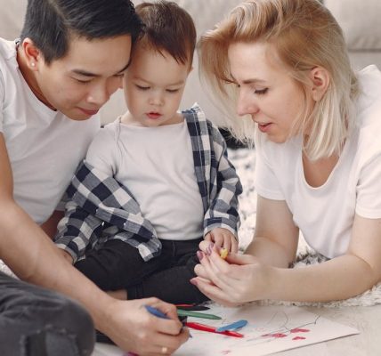 Loving family creating art together, fostering play and connection indoors.